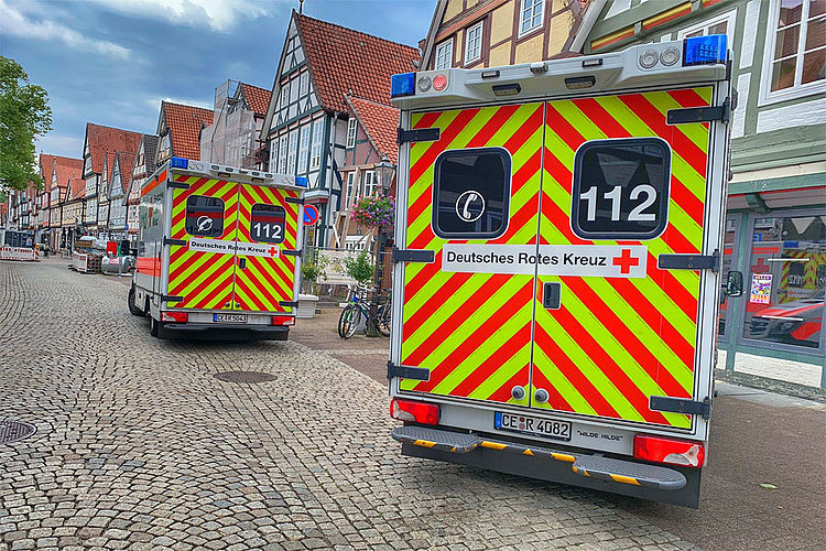 Zwei Rettungswagen stehen in der Celler Altstadt vor historischen Fachwerkhäusern. Die Fahrzeuge sind von hinten zu sehen, eingebettet in das Stadtbild.