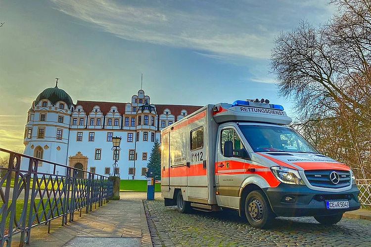 Ein Rettungswagen steht auf der Brücke vor dem Celler Schloss in früher Abendstunde.