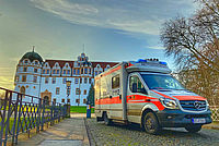 Ein Rettungswagen steht auf der Brücke vor dem Celler Schloss in früher Abendstunde.