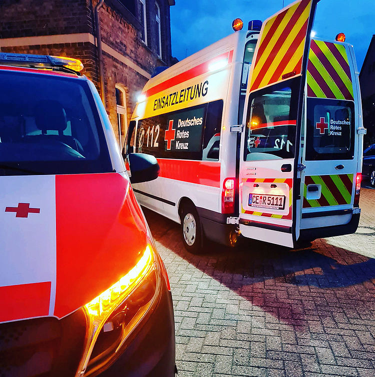 Ein Notarzteinsatzwagen und ein Einsatzleitwagen stehen im Abendlicht während eines laufenden Einsatzes. Die Fahrzeuge sind beleuchtet und vermitteln eine ruhige, aber konzentrierte Einsatzatmosphäre.